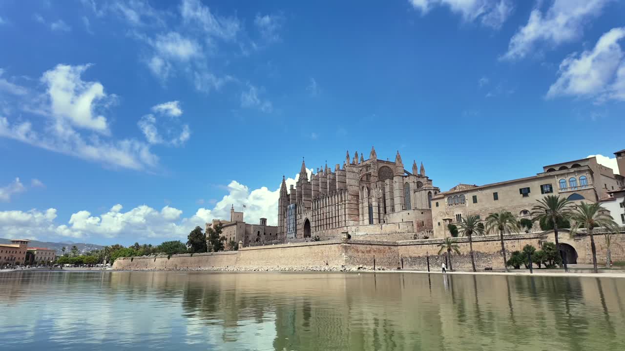 Timelapse of Palma de Mallorca ciity center and the Cathedral reflected on the water, under a blue sky with chaning clouds