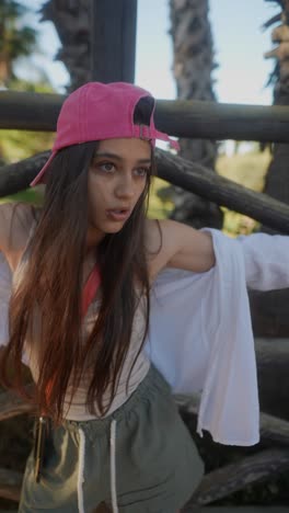 teenage girl posing outside near wooden fence