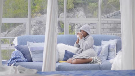 woman relaxing with a cup of tea in a cozy sunroom