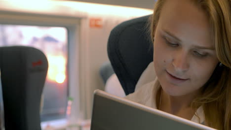 una mujer de negocios usa una tableta electrónica en el tren.