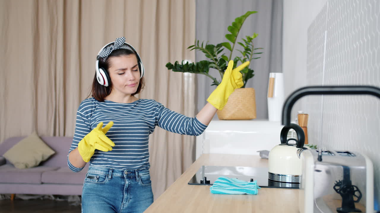 Woman Cleaning the Kitchen While Listening to Music