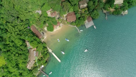 aerial view of drone over the coastal beach , green forest over the coastal beach, boats on the coastal beach in the ocean