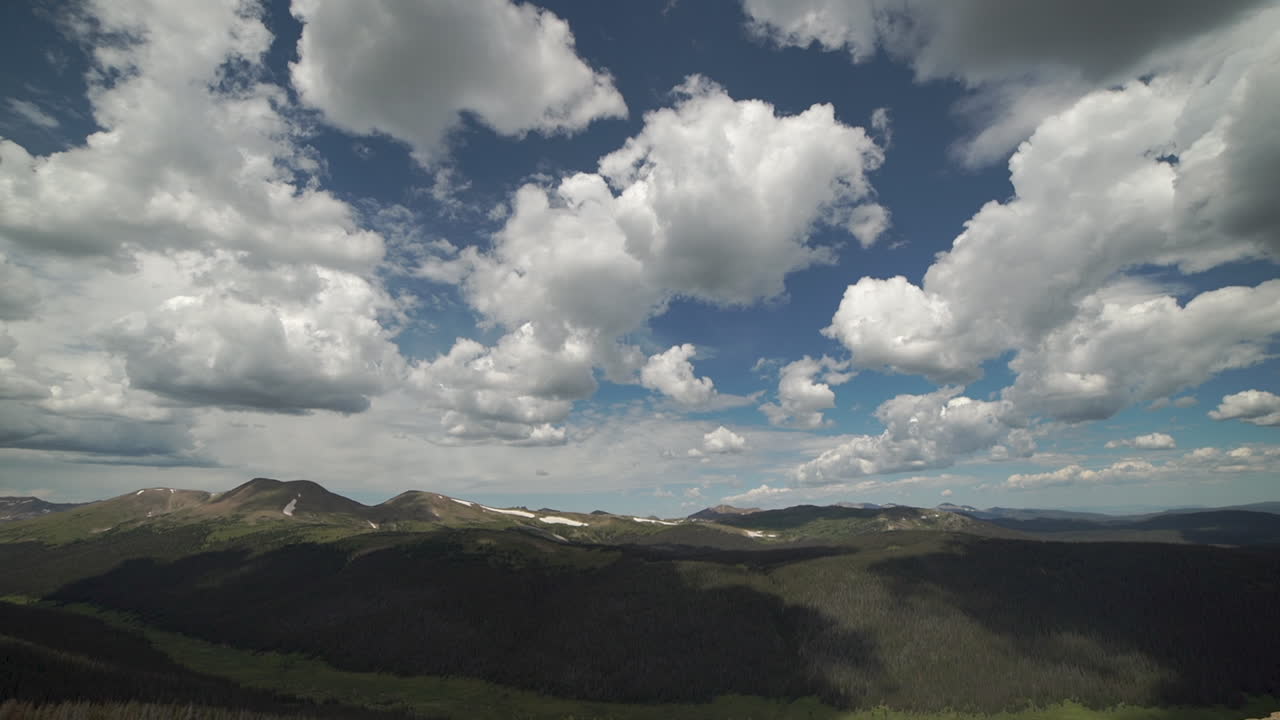 lapso de tiempo de nubes hinchadas sobre la cordillera y el valle debajo