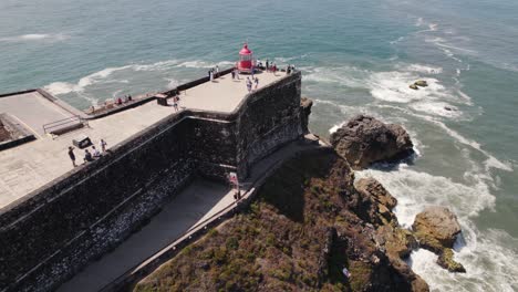 tourists at nazare red lighthouse at saint michael the archangel fort in portugal