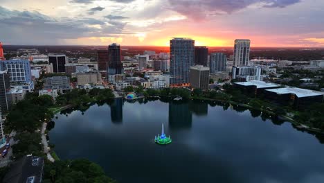 el horizonte del centro de orlando al atardecer con la fuente iluminada del lago eola en el centro