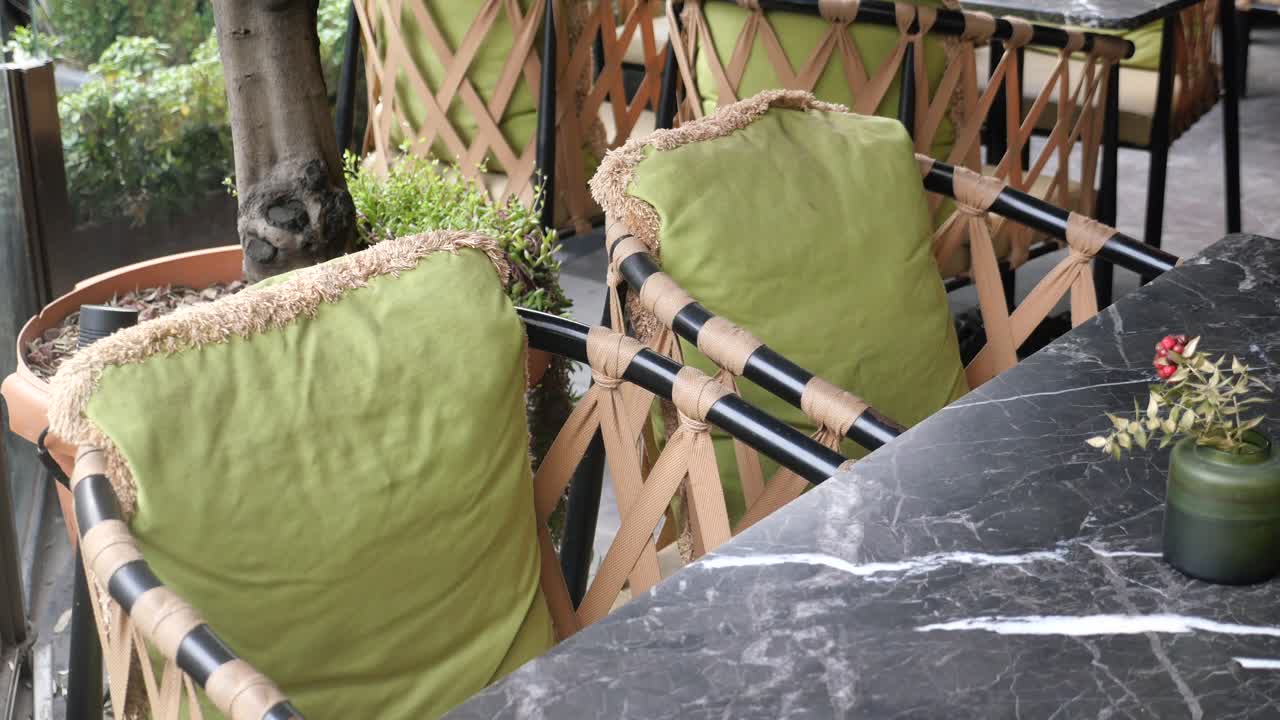 녹색 베개와 대리석 테이블이 있는 야외 카페 마당