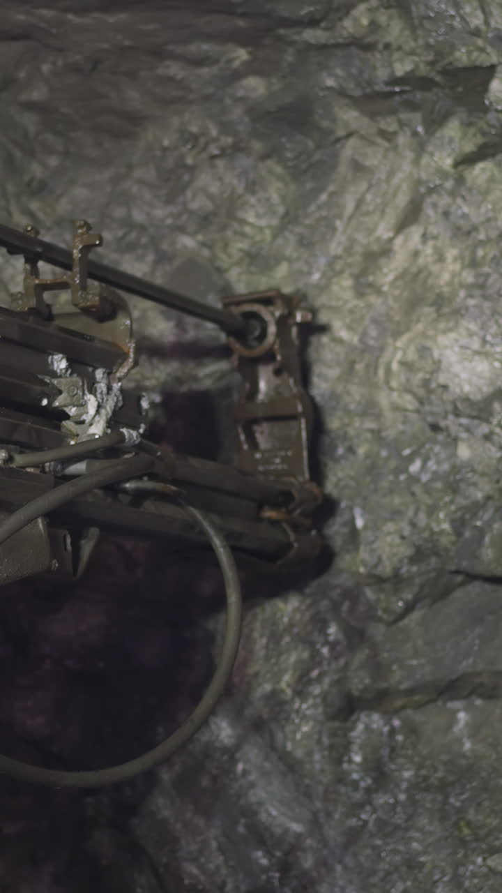 Robot drill makes hole in hard rock for setting explosives in ore mine. Professional machinery equipment helps to get natural resources closeup
