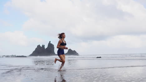 sands of transformation: slow motion morning run of an athletic woman by the ocean