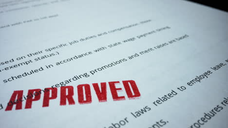 legal contract lying on table. red stamp with text approved on business contract