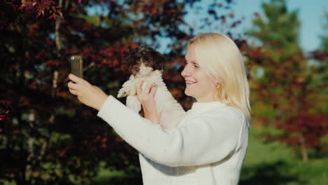 frau macht selfie mit einem welpen