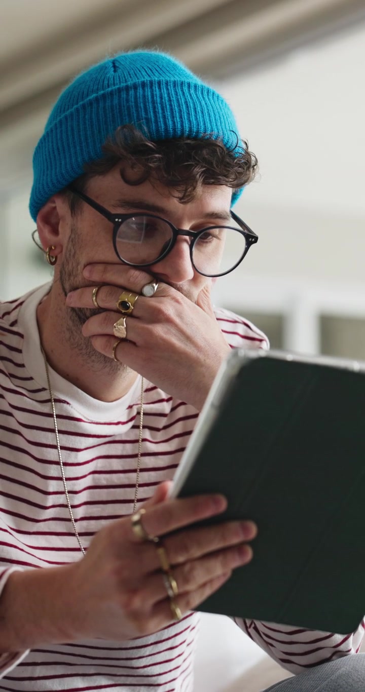 Young Man Using Tablet and Thinking in Modern Home