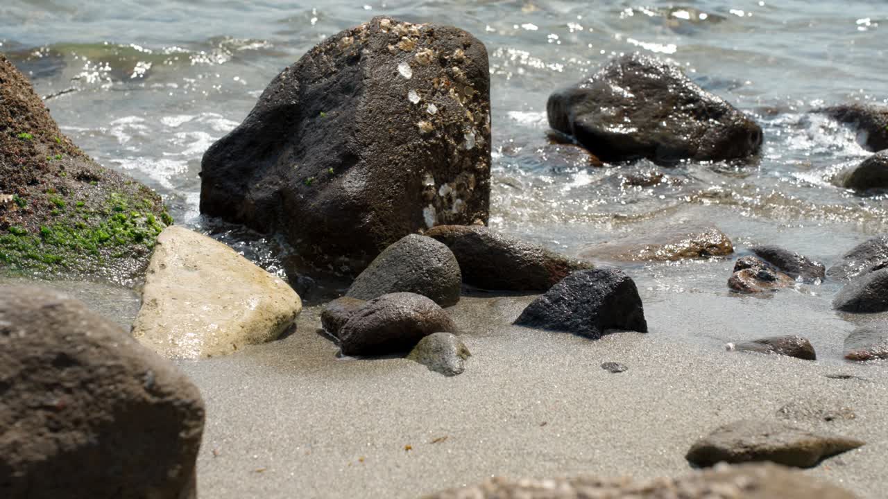 바다 의 모래 해변 에 굴러가는 큰 바위