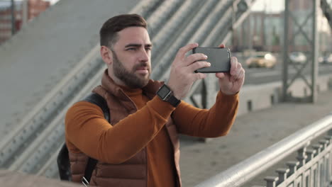 male tourist taking pictures from bridge