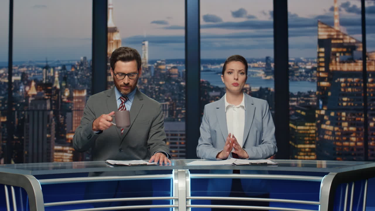 이 부부는 멀티미디어 채널에서 뉴스를 보도하고 있습니다. 기자들이 논의하고 있습니다.