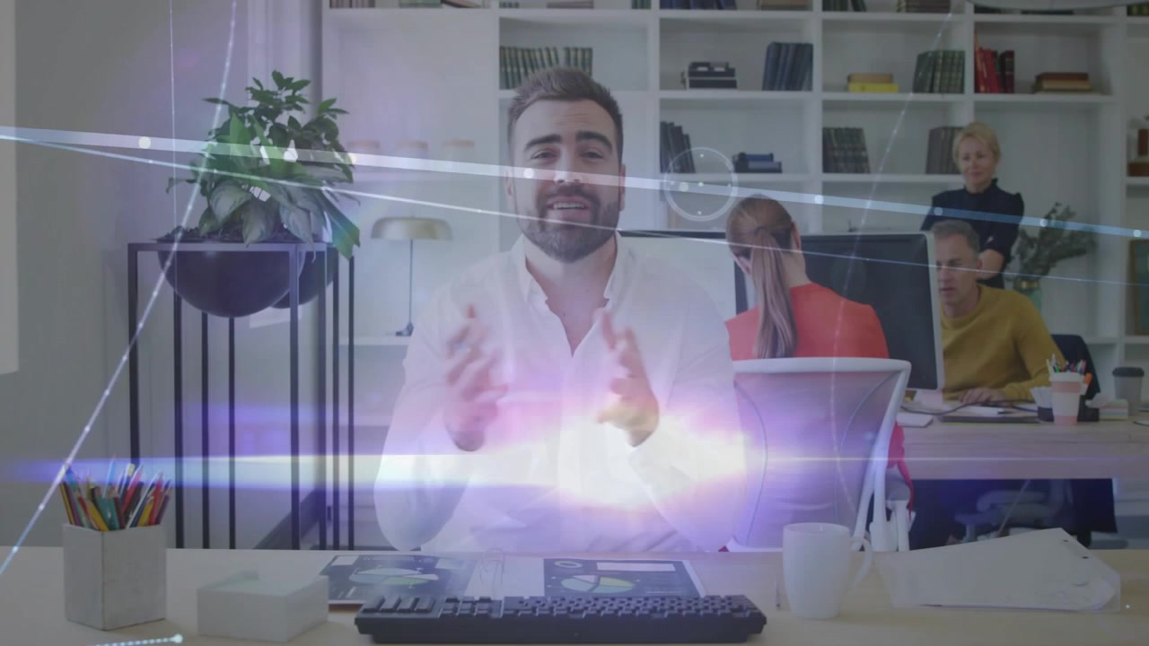 Presentatore uomo alla reception che presenta un aggiornamento dell'ufficio, con sovrapposizioni che appaiono a metà e mostrano dati.