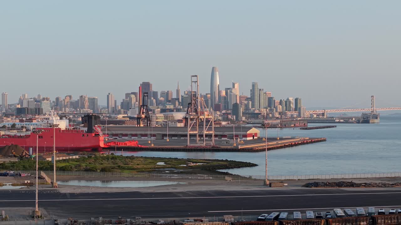 An aerial zoom out shot of downtown San Francisco with industry cranes in the foreground.