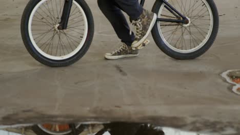 BMX-Fahrer-Nutzt-Smartphone-In-Einem-Leeren-Lagerhaus