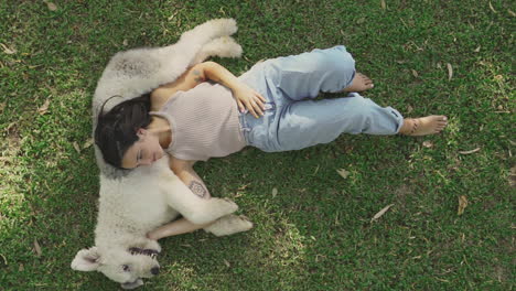 Frau-Liegt-Mit-Ihrem-Großen-Hund-Im-Gras-1