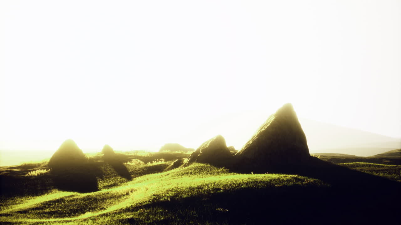 Scenic view of green hills and rocky formations under a bright sun