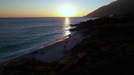 Puesta-De-Sol-En-La-Playa-De-Drimadhes,-Sol-Reflejado-En-El-Agua-Del-Mar,-Velada-Romántica-En-La-Costa-Mediterránea