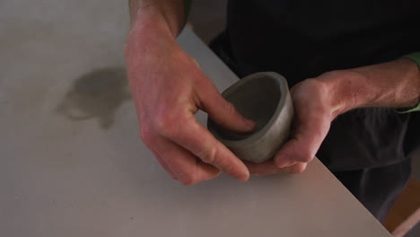 Close-up-view-of-male-potter-working-on-clay-pots-at-pottery-studio