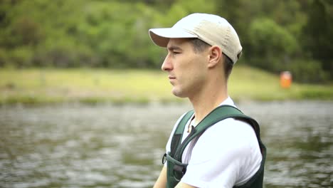 shot of a caucasian male fisherman casting his hook while fly fishing