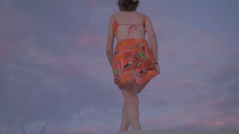 mujer caminando por la arena