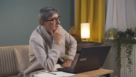el viejo mirando la computadora portátil es considerado.