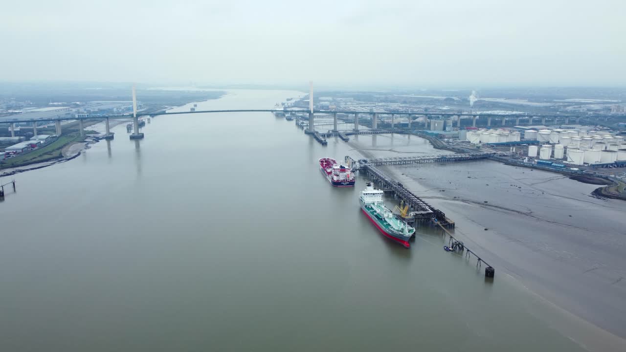 Aerial view of ships on the river near a bridge and industrial area