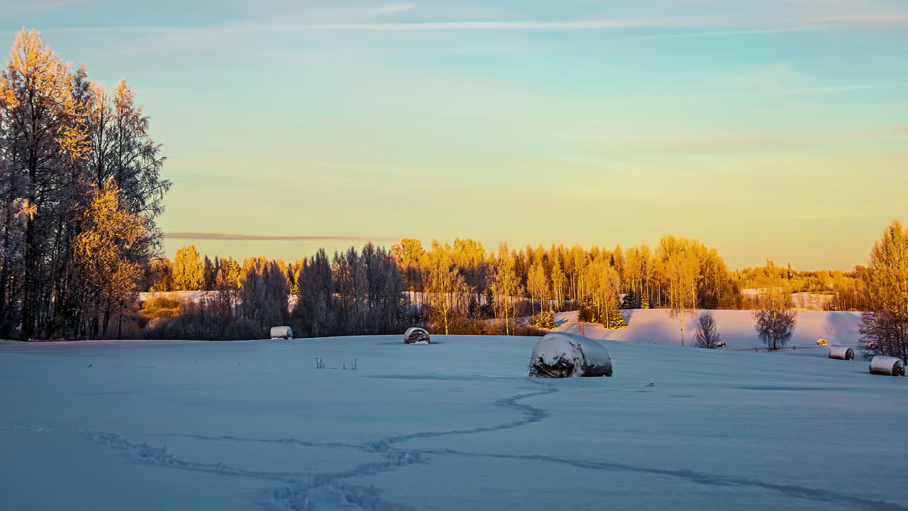 Skygger og sollys beveger seg over skog og snødekte jorder, timelapse