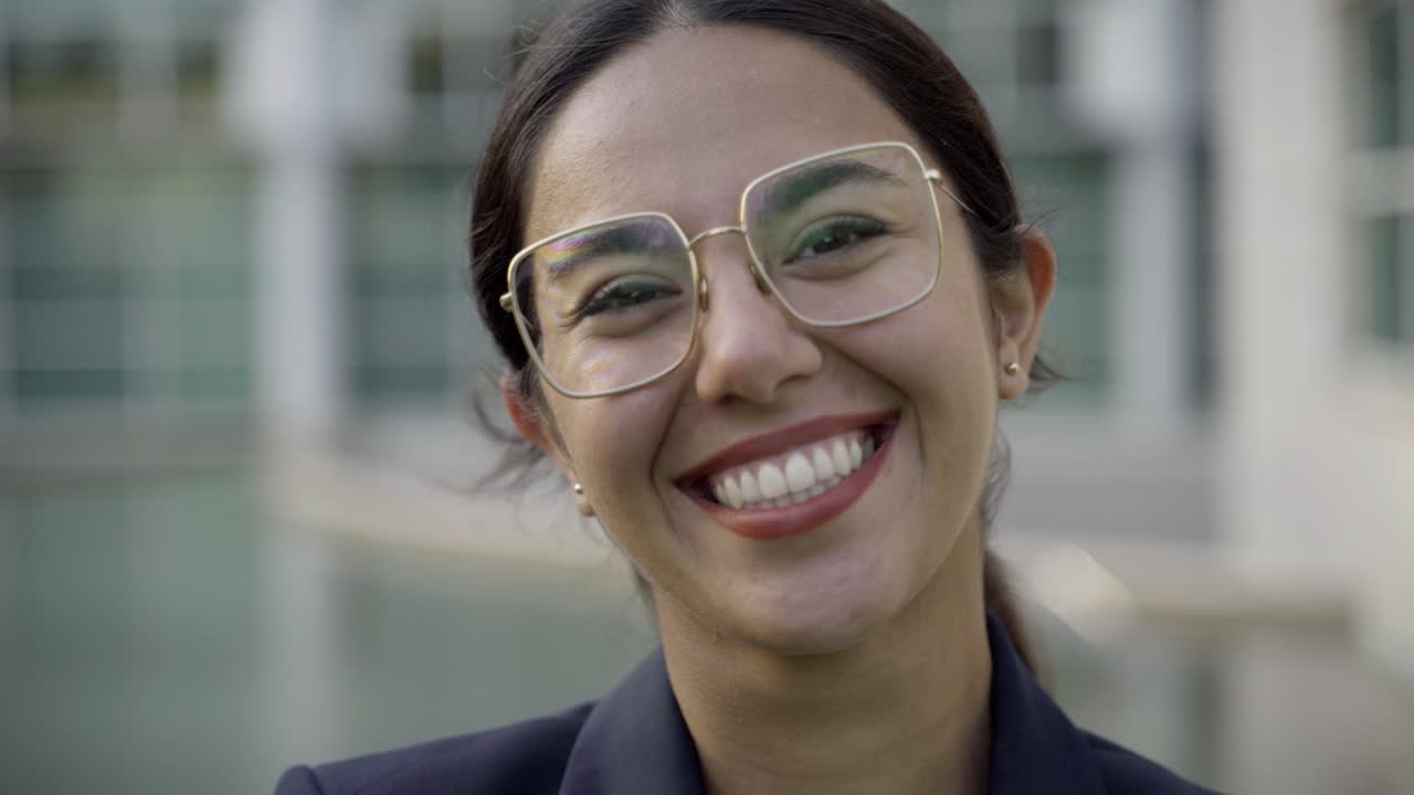 una hermosa mujer asiática sonriente con gafas posando en la calle