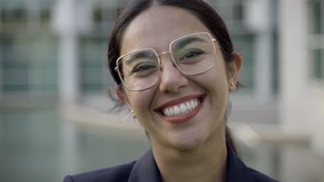 Hermosa-Mujer-Asiática-Sonriente-Con-Anteojos-Posando-En-La-Calle