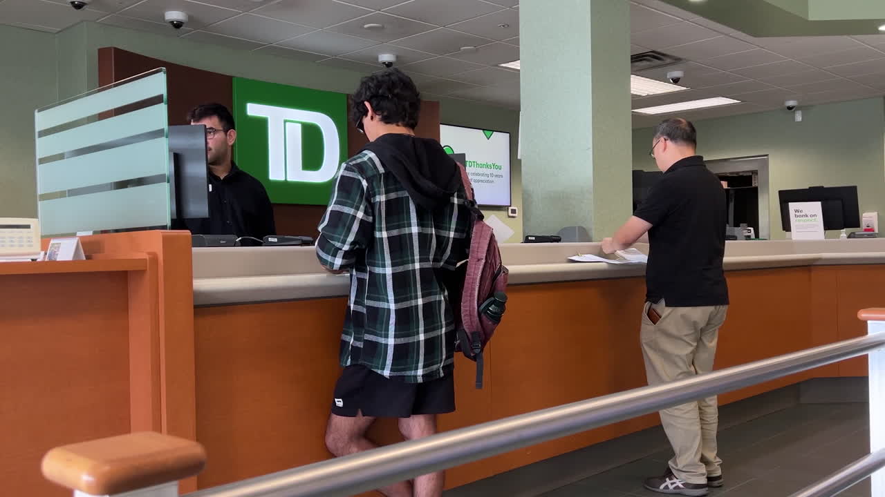 Motion of people line up waiting for the service inside TD Bank with 4k resolution