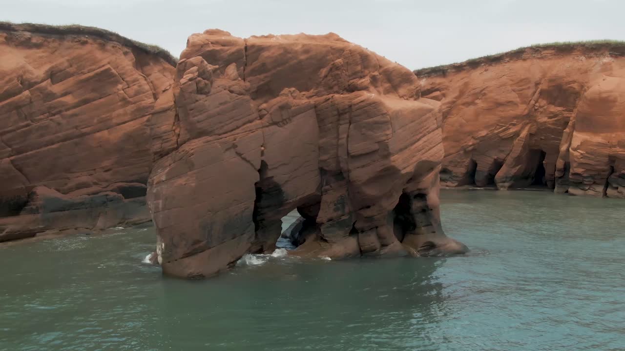 Spectacular Aerial orbit shot of big Magdalen Islands ocean rock formation