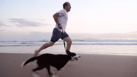 happy man running dog on beach lifestyle steadicam shot