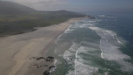 vista aérea de arriba hacia abajo de la playa de arda en el océano atlántico en portugal en un día soleado con olas perfectas y arena amarilla