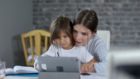 madre sentada con su hija en el escritorio