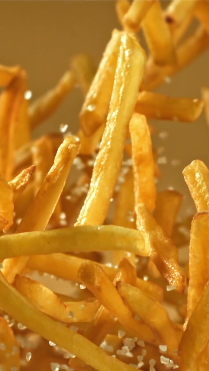 Crispy French Fries Falling with Salt in Slow Motion