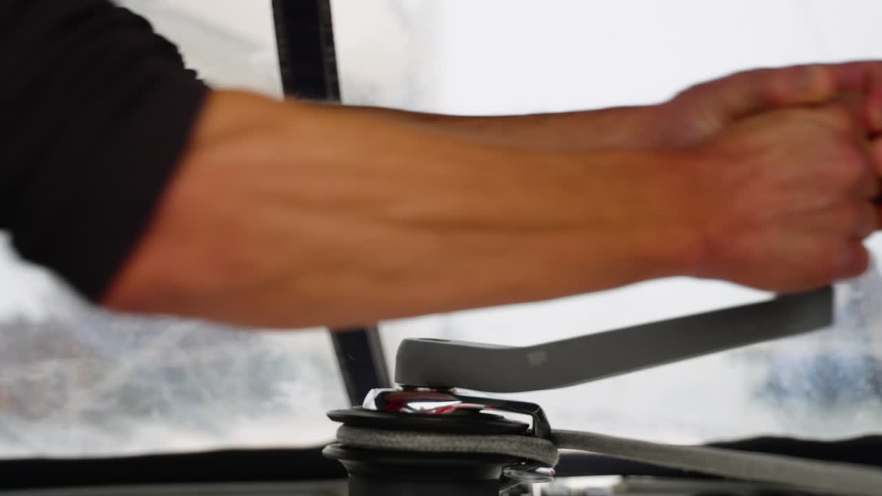 toma cinematográfica de cerca de una persona tirando de la cuerda del cabrestante en un barco en el mar - cámara lenta