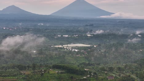 countryside of bali with volcano on horizon. farming villages and tropical landscape.