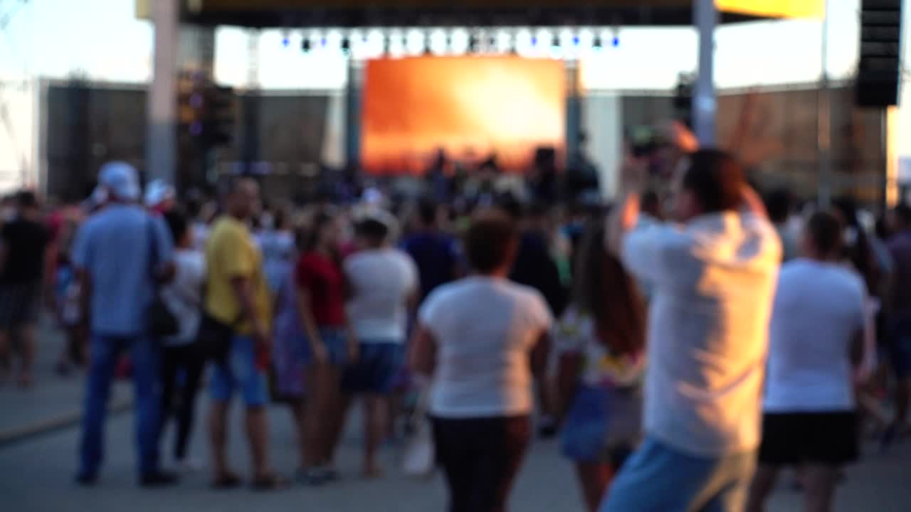 Concert on the stage. Crowd of people and musicians on the scene. Out of focus