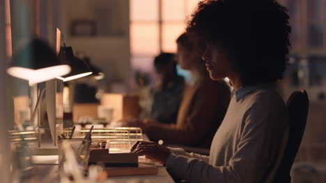 Junge-Afroamerikanische-Geschäftsfrau-Mit-Afro-Arbeitet-Spät-Am-Computer-Und-Tippt-E-Mails-Und-Genießt-Online-Netzwerkunterstützung-Im-Büro-Bei-Sonnenuntergang