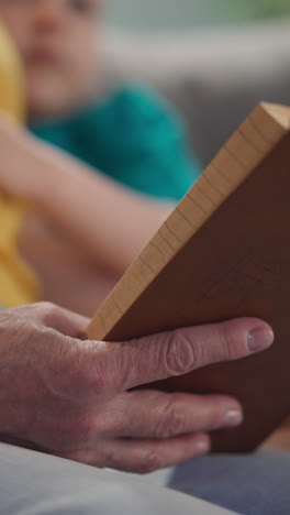 grandmother reads an old book to kids, a close-up book, a home library, slow motion