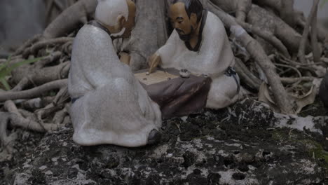 pequeña figura de porcelana en el árbol bonsai