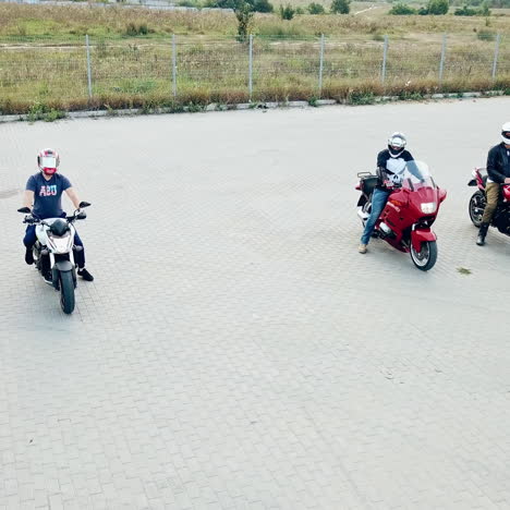 three motocyclists men riding their vehicles in a high speed outdoors. professional motobikers in protective helmets drive on the road at daytime.