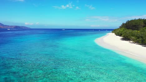 a stunning scenery of blue calm ocean with glorious trees and cloudy blue sky above in bali, indonesia