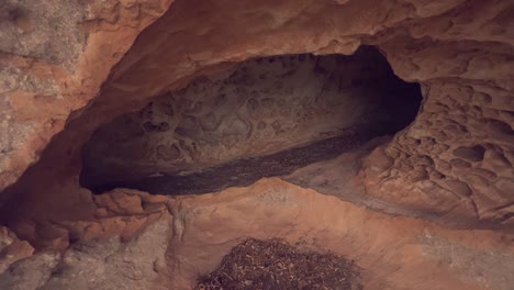 Entering-the-cave,-stony-and-rocky-cave-entrance,-daytime-capture-of-walking-into-hole-made-in-stones,-natural-construction-concept