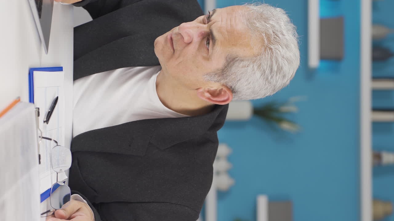 홈 오피스 직원의 수직 비디오 그가 읽고 보는 것에 충격을 받았습니다.