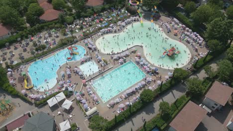 aerial shot of people swimming at pool in camping bella italia in lake garda, italy