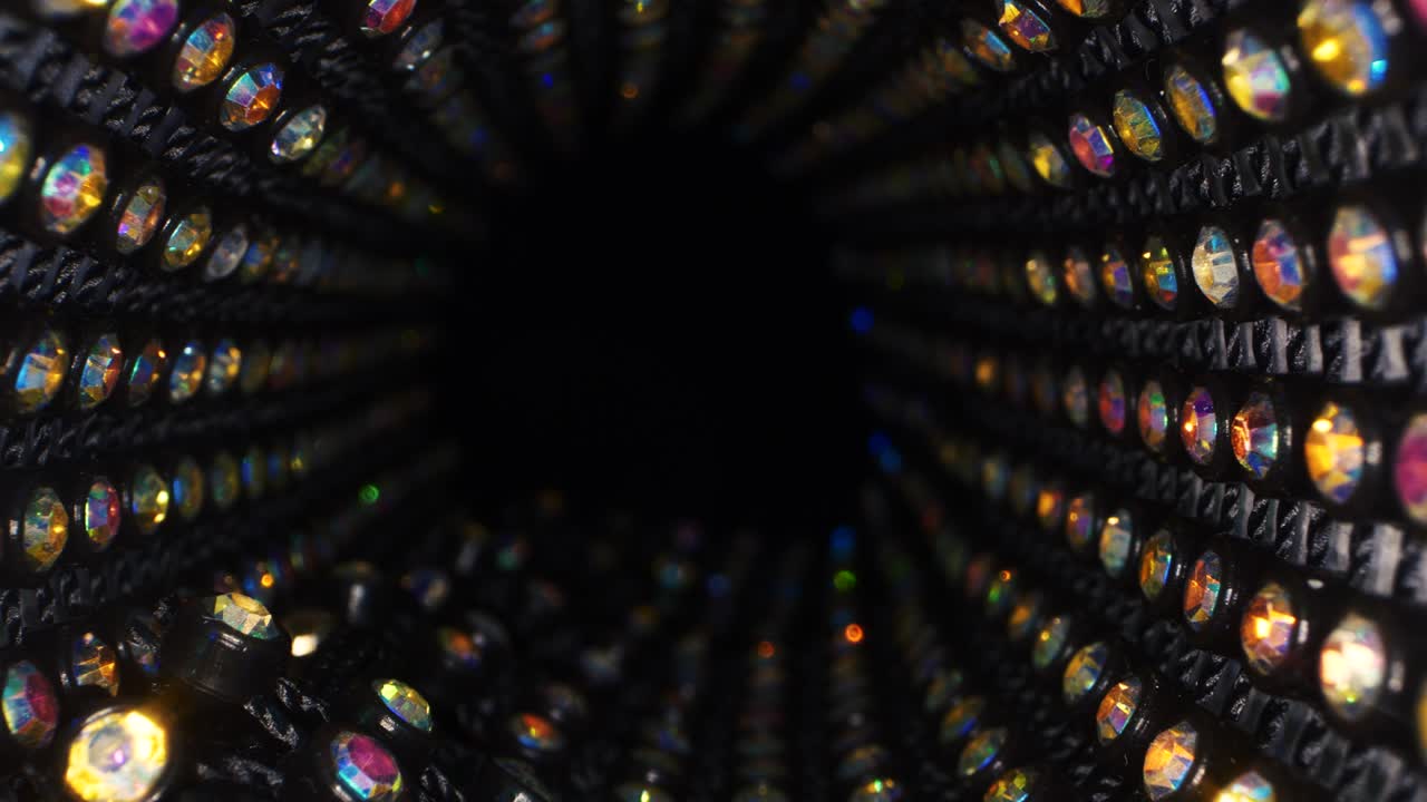 Diamanti colorati scintillanti astratti su sfondo nero, sfondo festivo luccicante 4K.